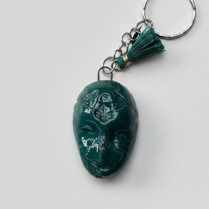 Doll Face Keyring – Enigmatic Ceramic Charm, 4 × 3 cm by Red Raven Pottery