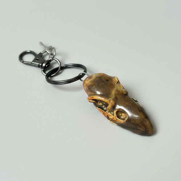 Raven Skull Ceramic Keychain – Charm of Death & Becoming, 5×2×1.5 cm by Red Raven Pottery