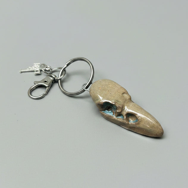 Raven Skull Ceramic Keychain – Charm of Death & Becoming, 5×2×1.5 cm by Red Raven Pottery