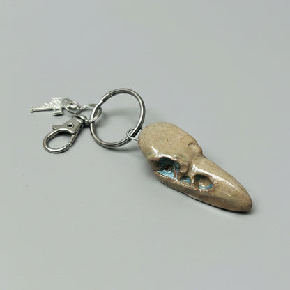 Raven Skull Ceramic Keychain – Charm of Death & Becoming, 5×2×1.5 cm by Red Raven Pottery